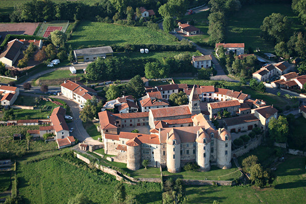 Légende photo : Vue aérienne du prieuré et du village de Pommiers-en-Forez – © DEPT42
